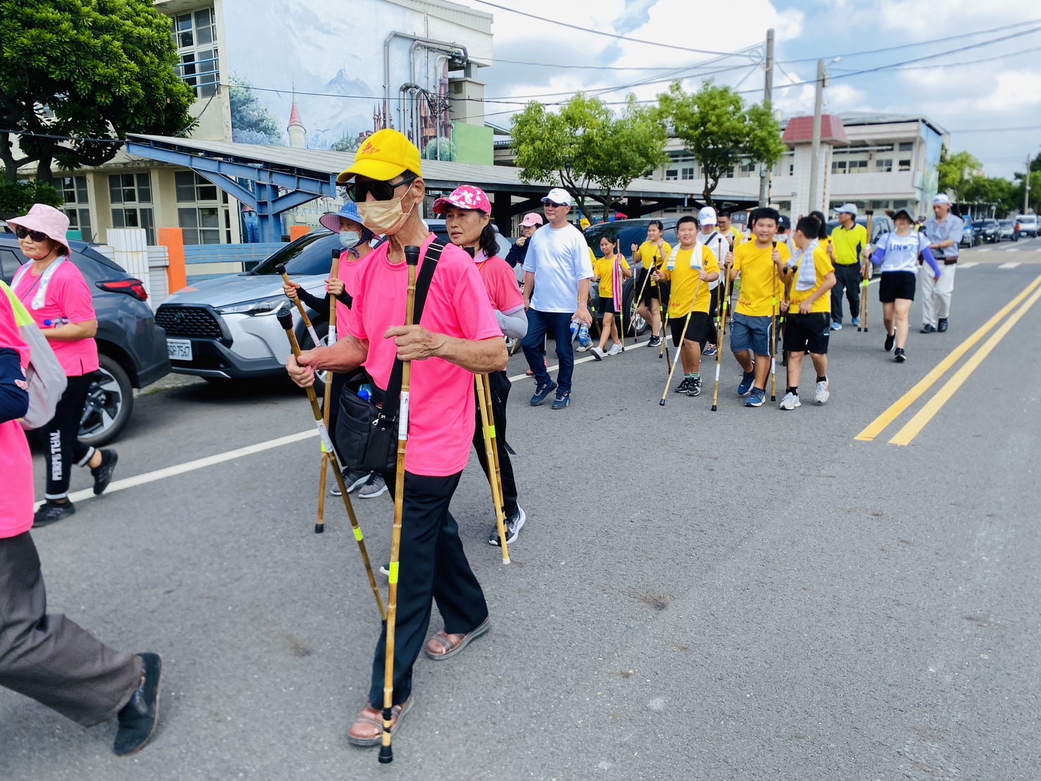 ▲崙背長者、小學生、德商等200餘人健行隊從崙背鄉中和國小出發,一起走過總長1.6公里的豐榮綠色隧道。(記者陳雅琪攝)