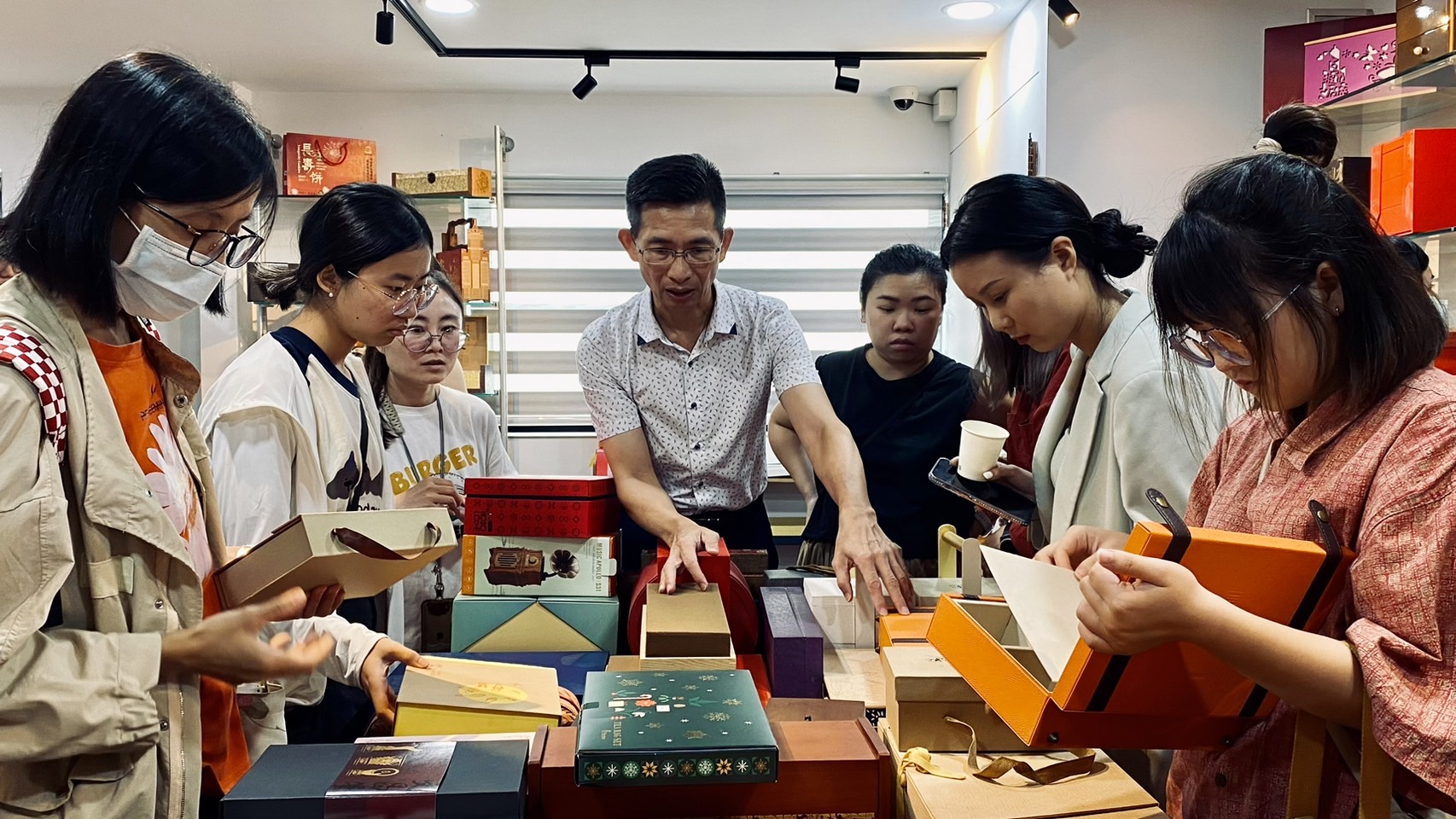 ▲仲威文化創意有限公司創辦人何正良（中）向團員介紹，如何結合文化元素進行創意開發及文創產業的市場策略。