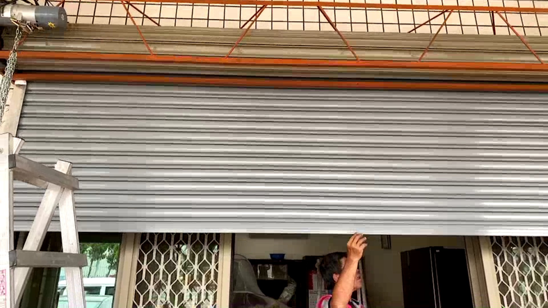 ▲好德做工行善團協會和慈化慈善會志工為二林鎮弱勢男子更換故障的鐵門。（記者張溎壕攝）