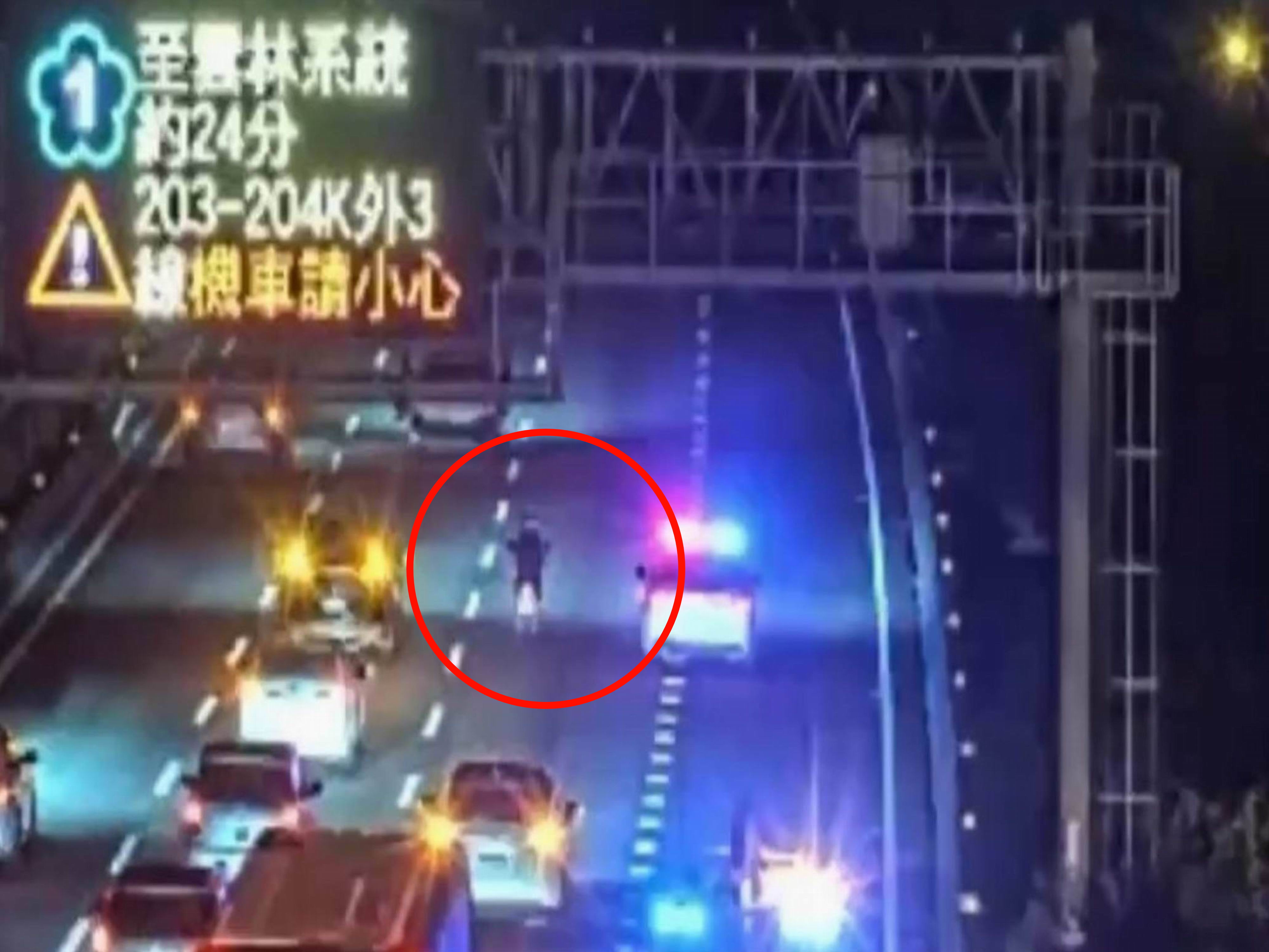 ▲山陀兒颱風夜，1名76歲老翁頂著強風騎機車沿國1南下狂奔，國道警方巡邏車與民車將他團團圍住，將人車沿途護送離開國道。（翻攝高速公路即時影像）