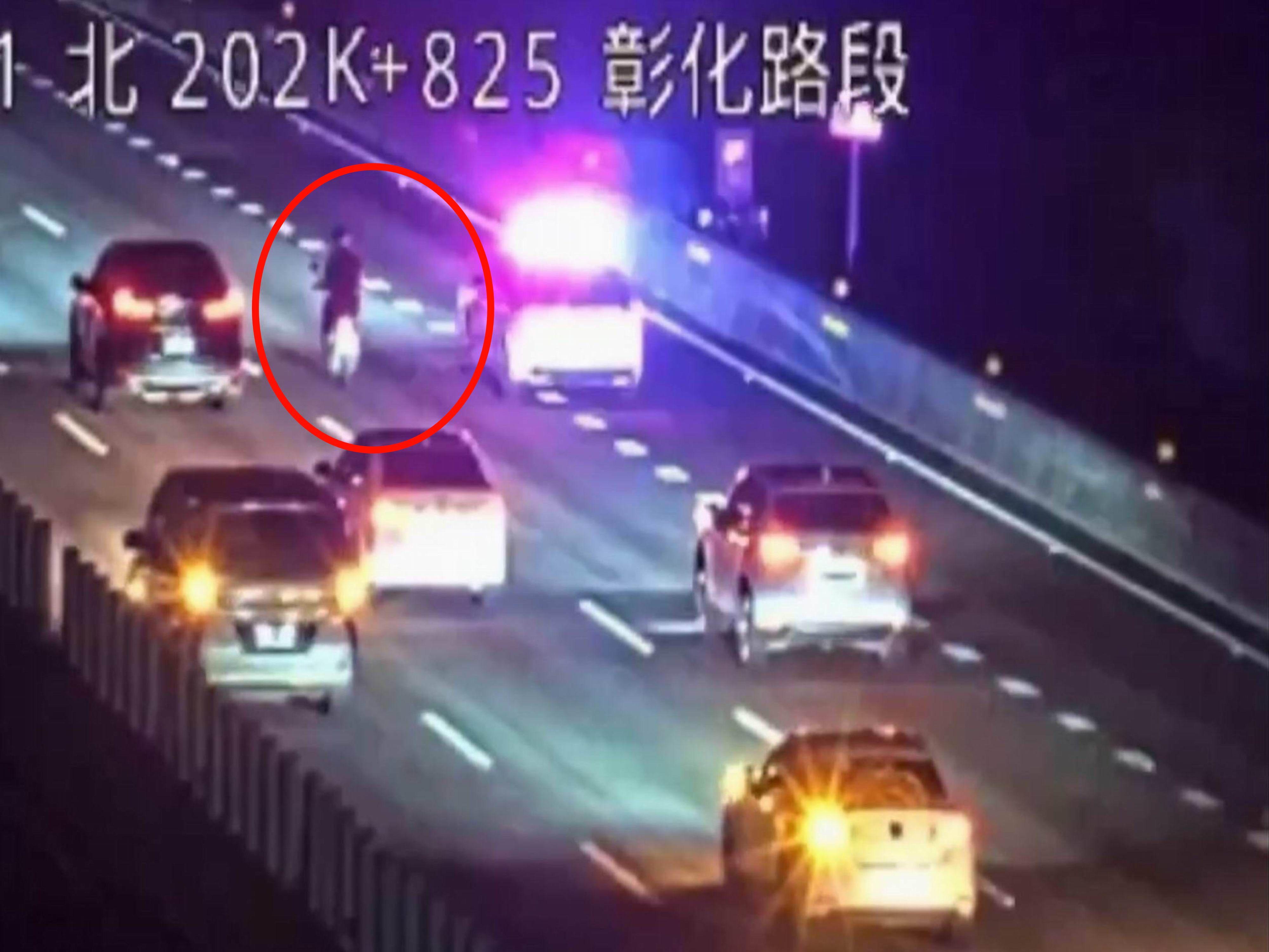 ▲山陀兒颱風夜，1名76歲老翁頂著強風騎機車沿國1南下狂奔，國道警方巡邏車與民車將他團團圍住，將人車沿途護送離開國道。（翻攝高速公路即時影像）