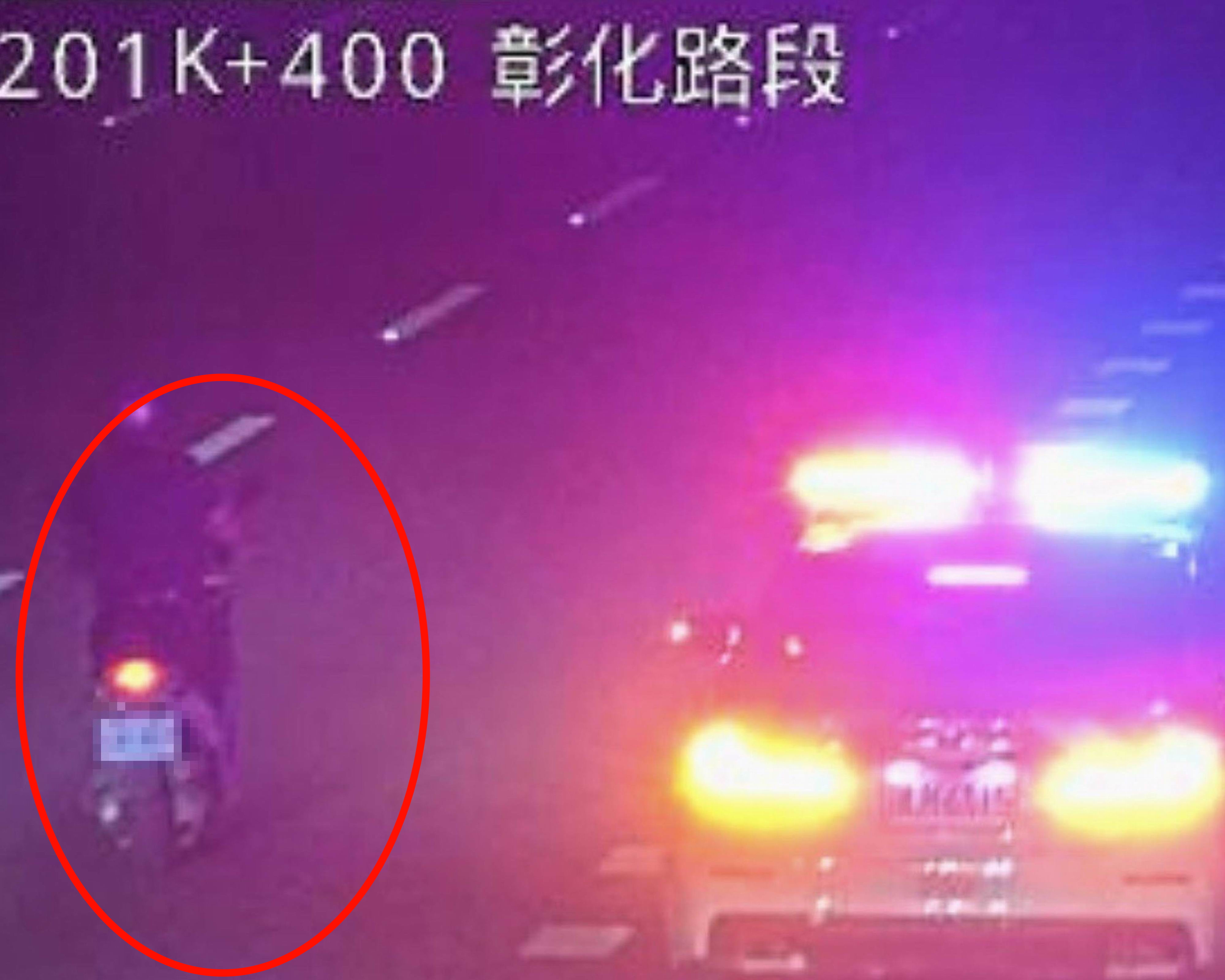▲山陀兒颱風夜，1名76歲老翁頂著強風騎機車沿國1南下狂奔，國道警方巡邏車與民車將他團團圍住，將人車沿途護送離開國道。（翻攝高速公路即時影像）