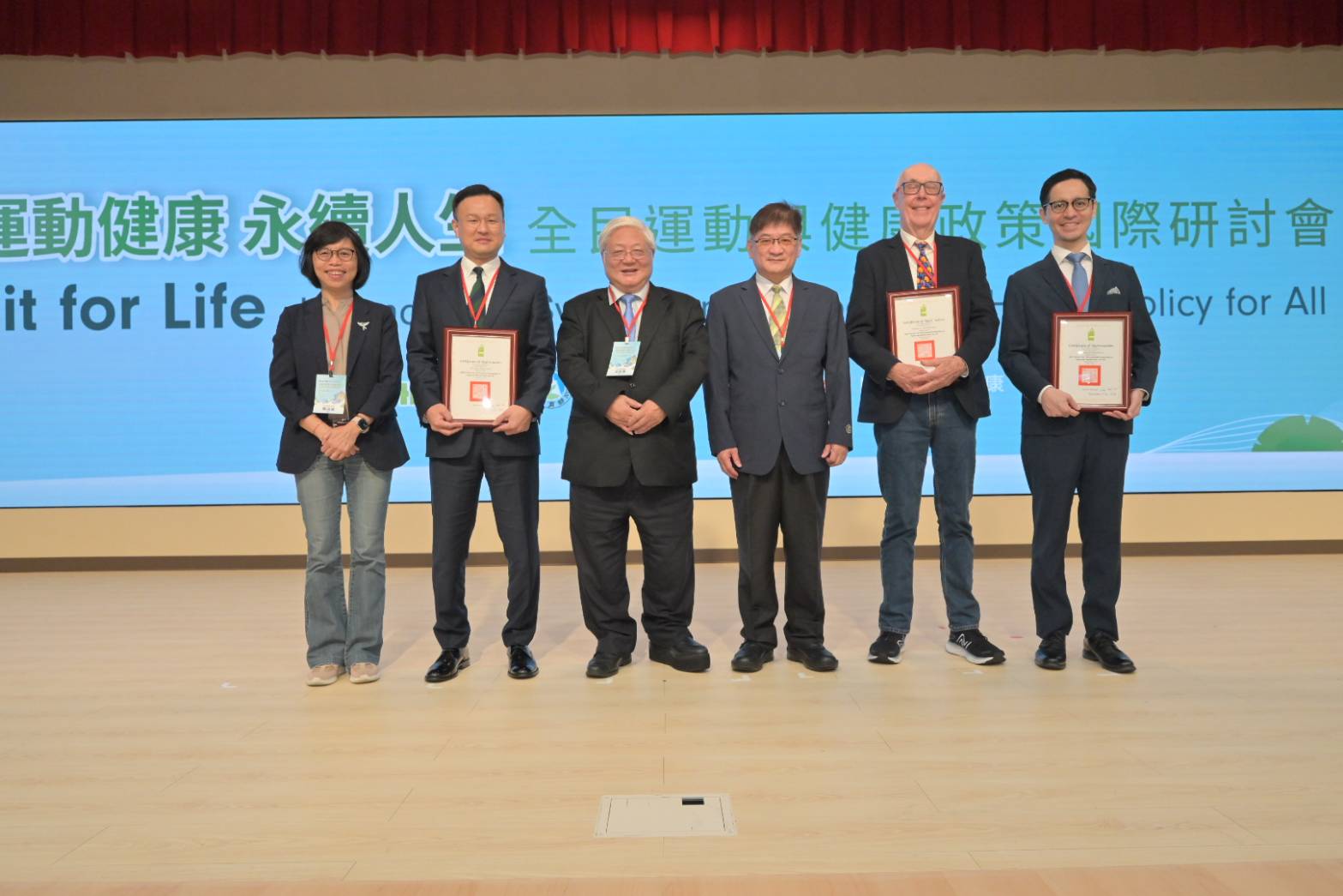 (左起)衛福部賈淑麗副署長、韓國釜山大學生醫研究所朴鐘煥教授、衛福部吳昭軍署長、教育部體育署洪志昌副署長、澳洲斯文本科技大學Neville Owen教授和日本東京大學醫學院公共衛生學研究所健康教育與健康社會學系鎌田真光教授進行大合照。(圖/國健署提供)