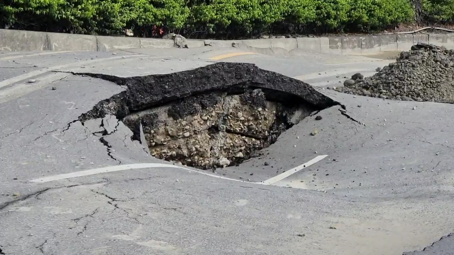 ▲花壇鄉省道台一線中山路「炸出一個大洞」，黃泥沖出路面，路面突炸裂成「波浪狀」，猶如被砲彈轟炸過。（記者張溎壕攝）