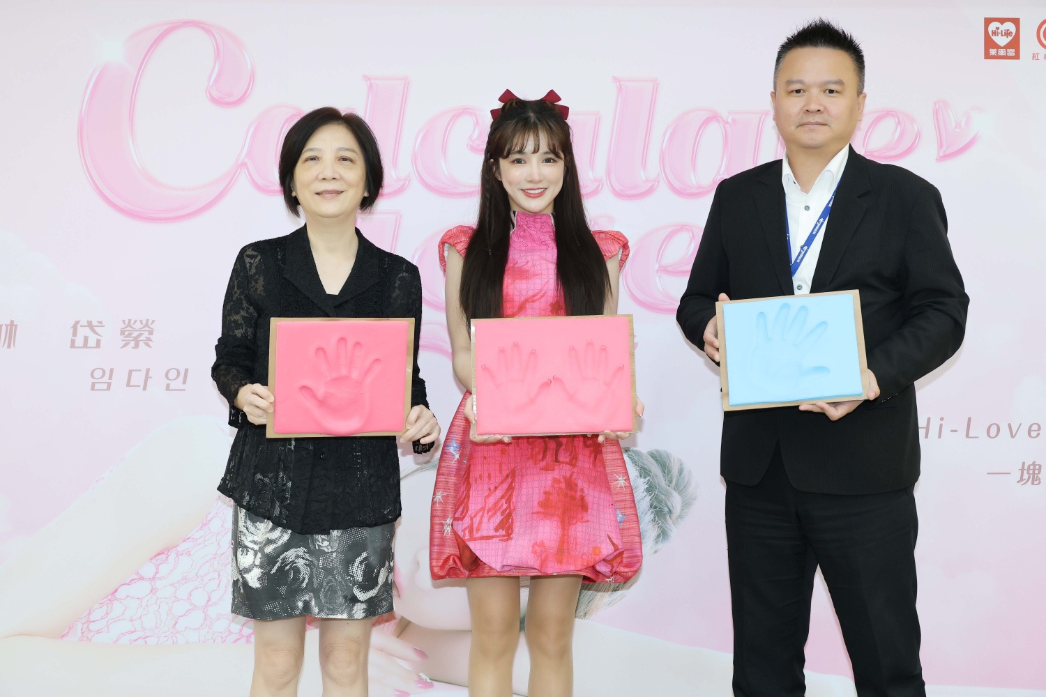 (左起) 紅心字會秘書長李顯文、林岱縈、萊爾富 劉嘉銓處長一起蓋下象徵「守護弱勢家庭兒童」的手模。 (圖/紅心字會提供)