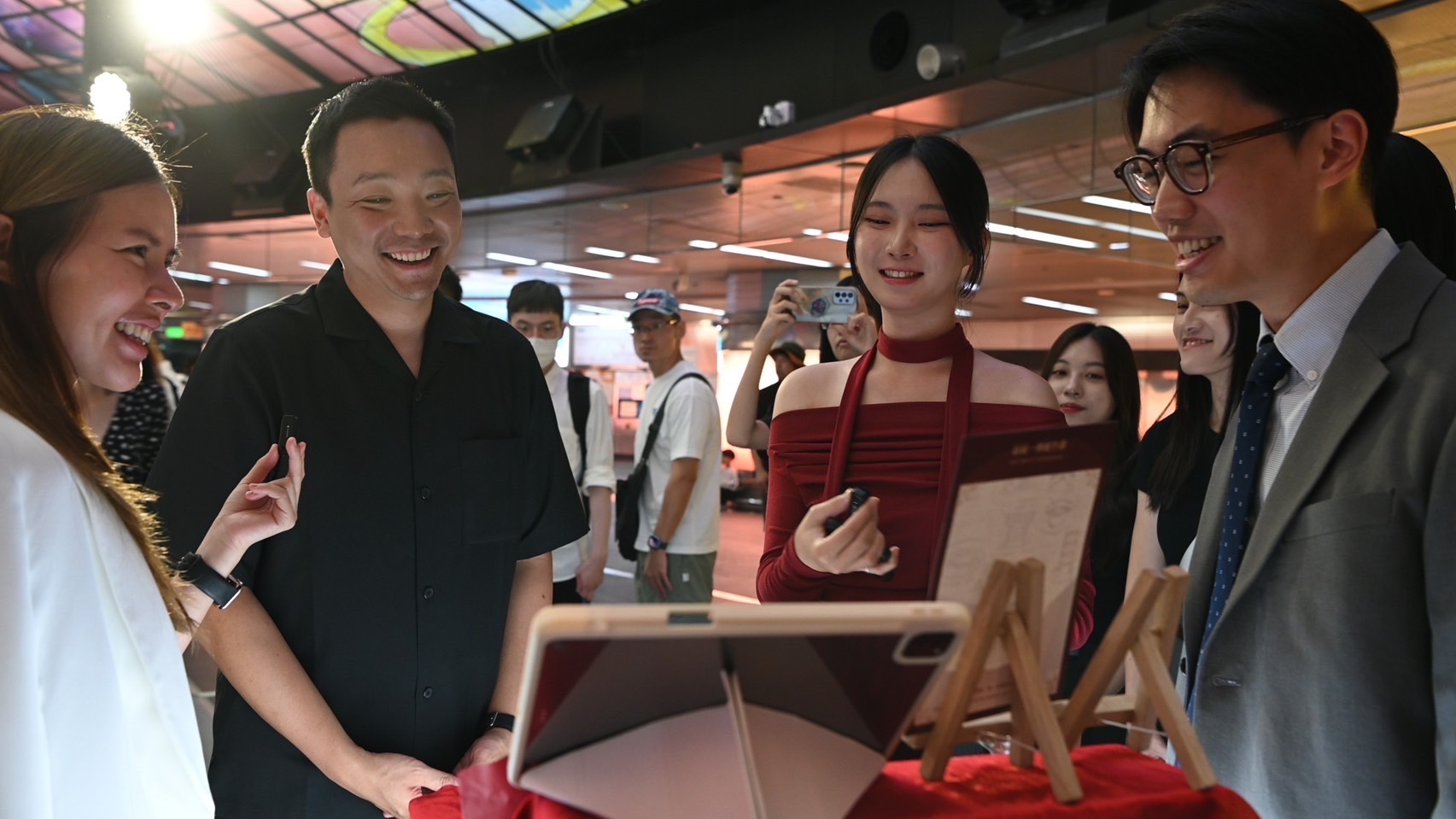 ▲高市青年局長張以理（左2）參觀得獎作品，並開心與設計團隊及企業主交流對話。(記者 吳月惠 翻攝)