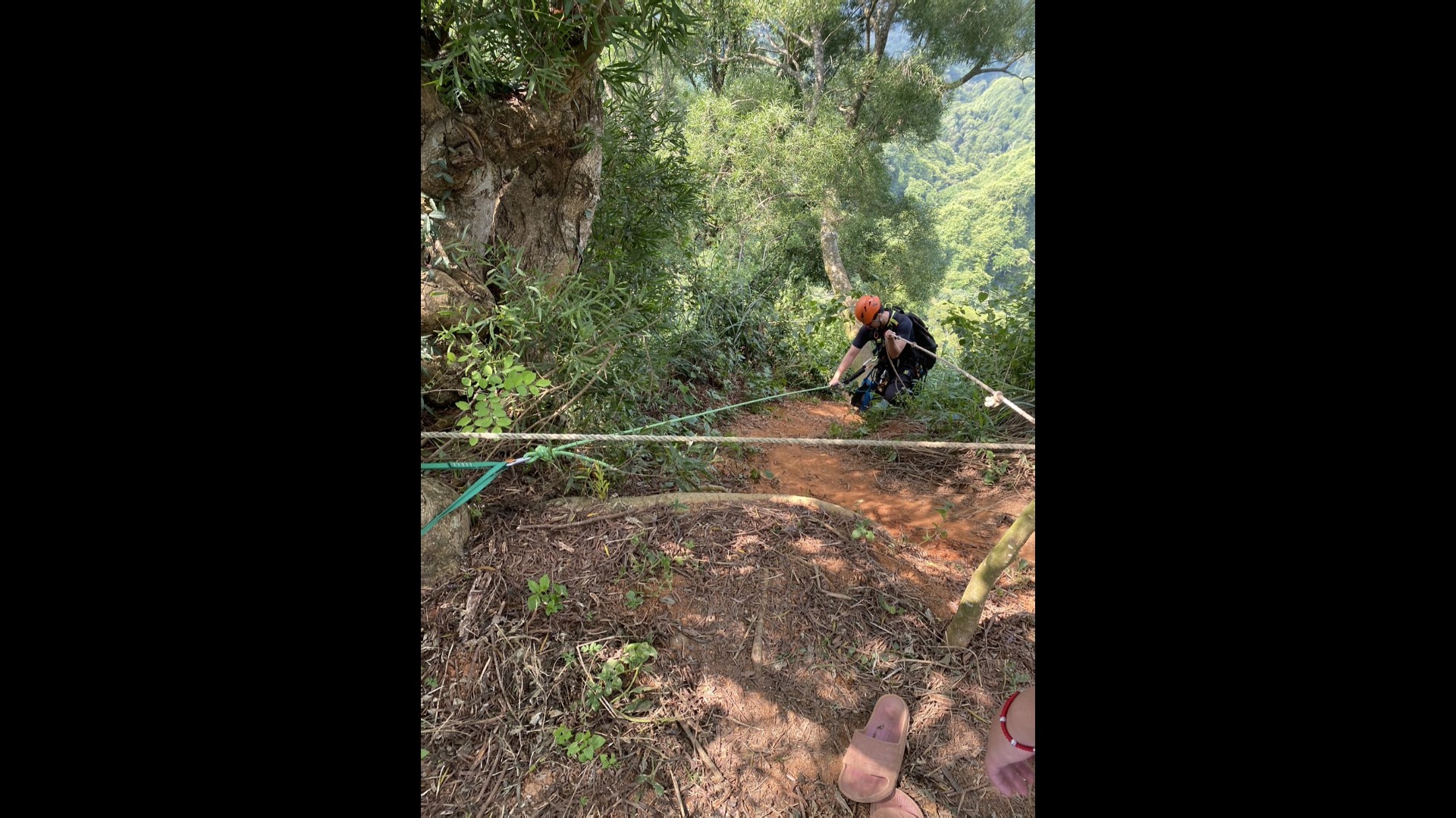 ▲彰化縣一對夫妻前往靠近南投縣的內樹尾山爬山，劉姓妻子在行走間不慎墜落50公尺深的山坡，消防員以繩索垂降救援。（彰化縣消防局提供）