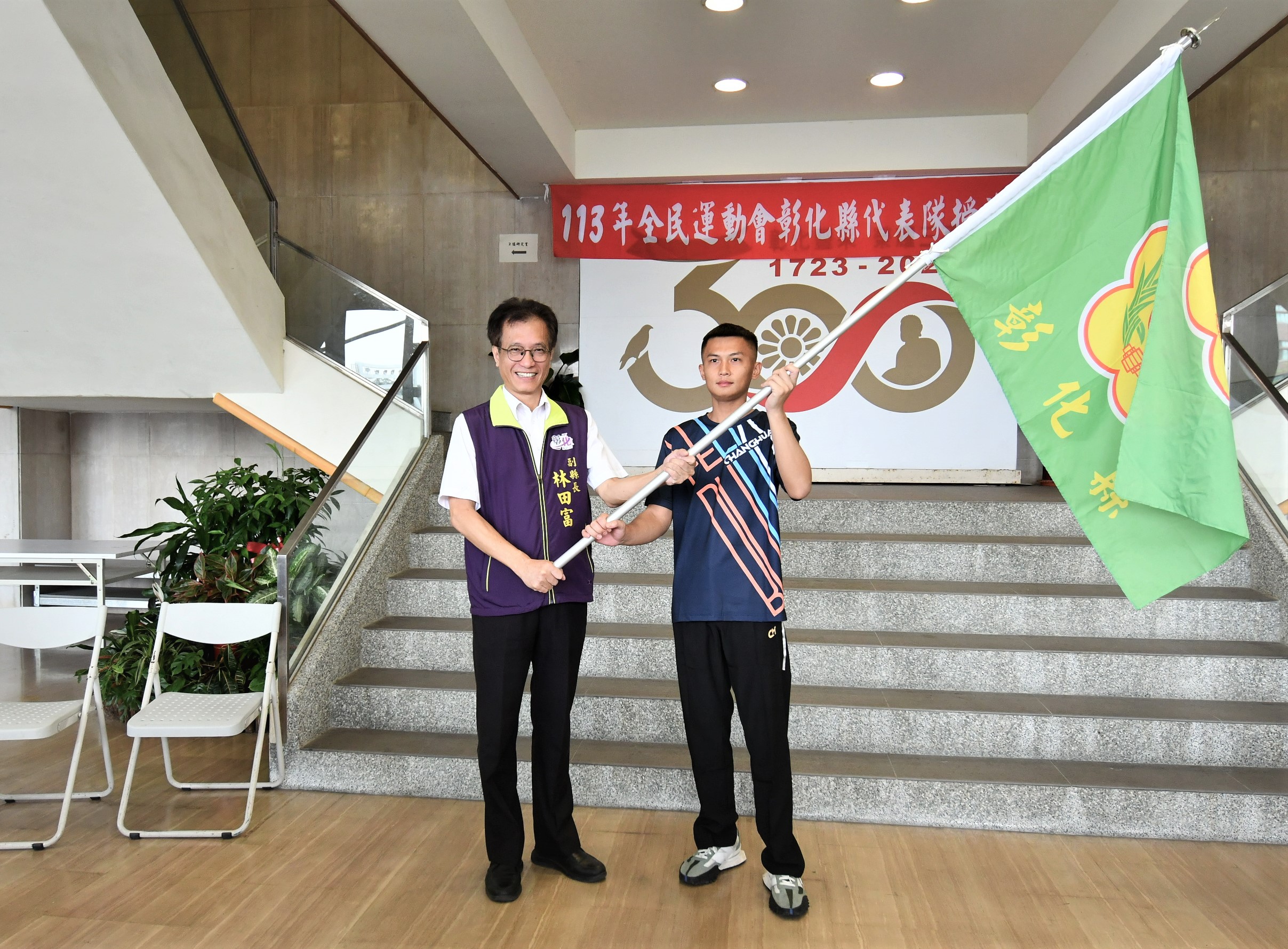 ▲113年全民運動會啦!彰化副縣長林田富代表縣長授旗給龍獅運動代表隊隊長黃君佑,象徵彰化代表隊正式出發,向金牌進軍。(記者張溎壕攝)