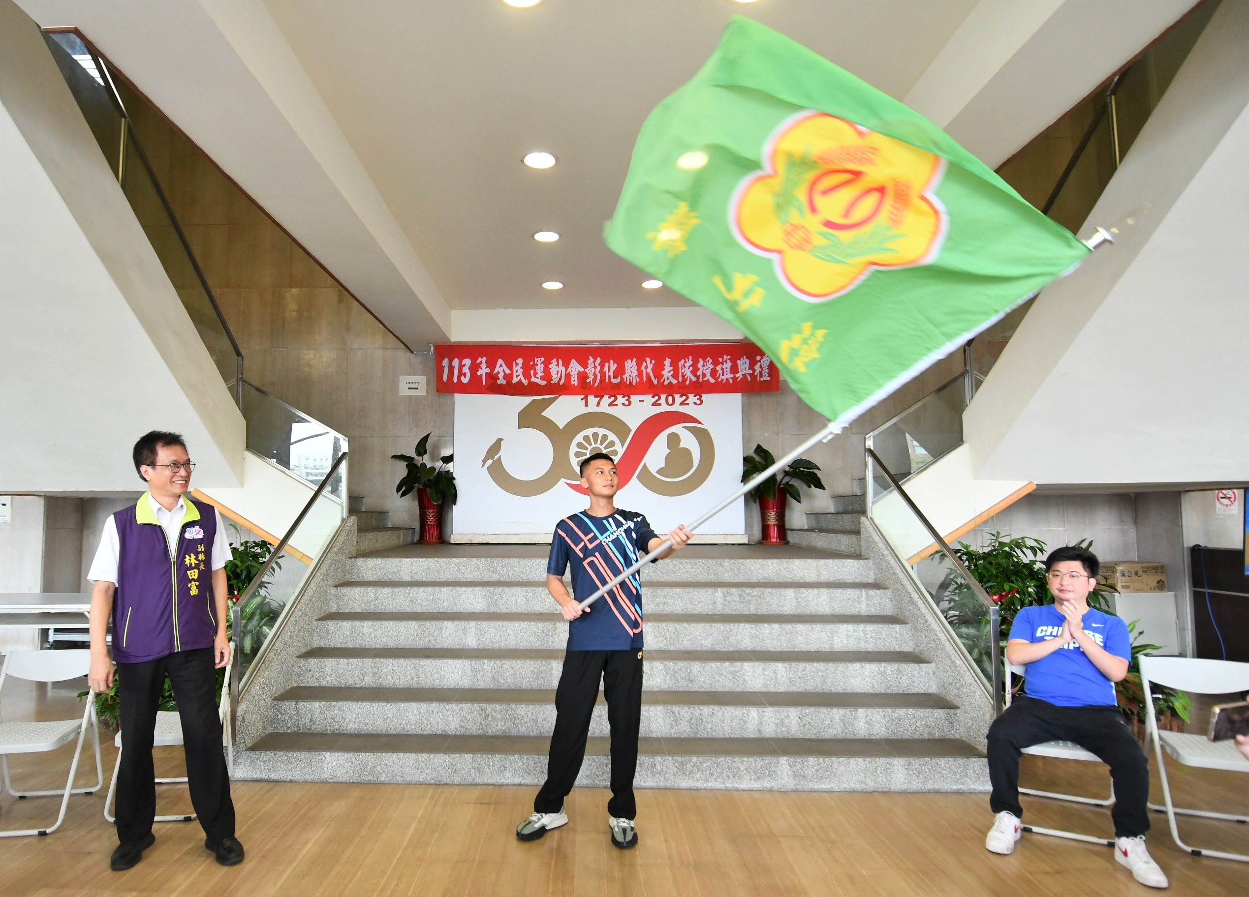 ▲113年全民運動會啦！彰化副縣長林田富代表縣長授旗給龍獅運動代表隊隊長黃君佑，象徵彰化代表隊正式出發，向金牌進軍。（記者張溎壕攝）