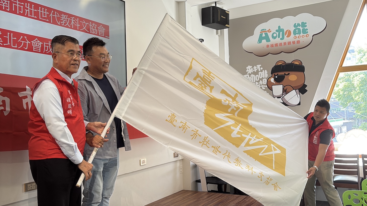 褚顯明理事長授旗給王莨耿分會長，象徵薪火相傳