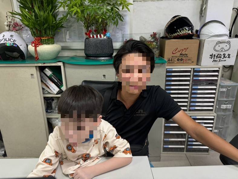 男童破涕而笑與父親在派出所內合影。(記者 黃荷琇翻攝)