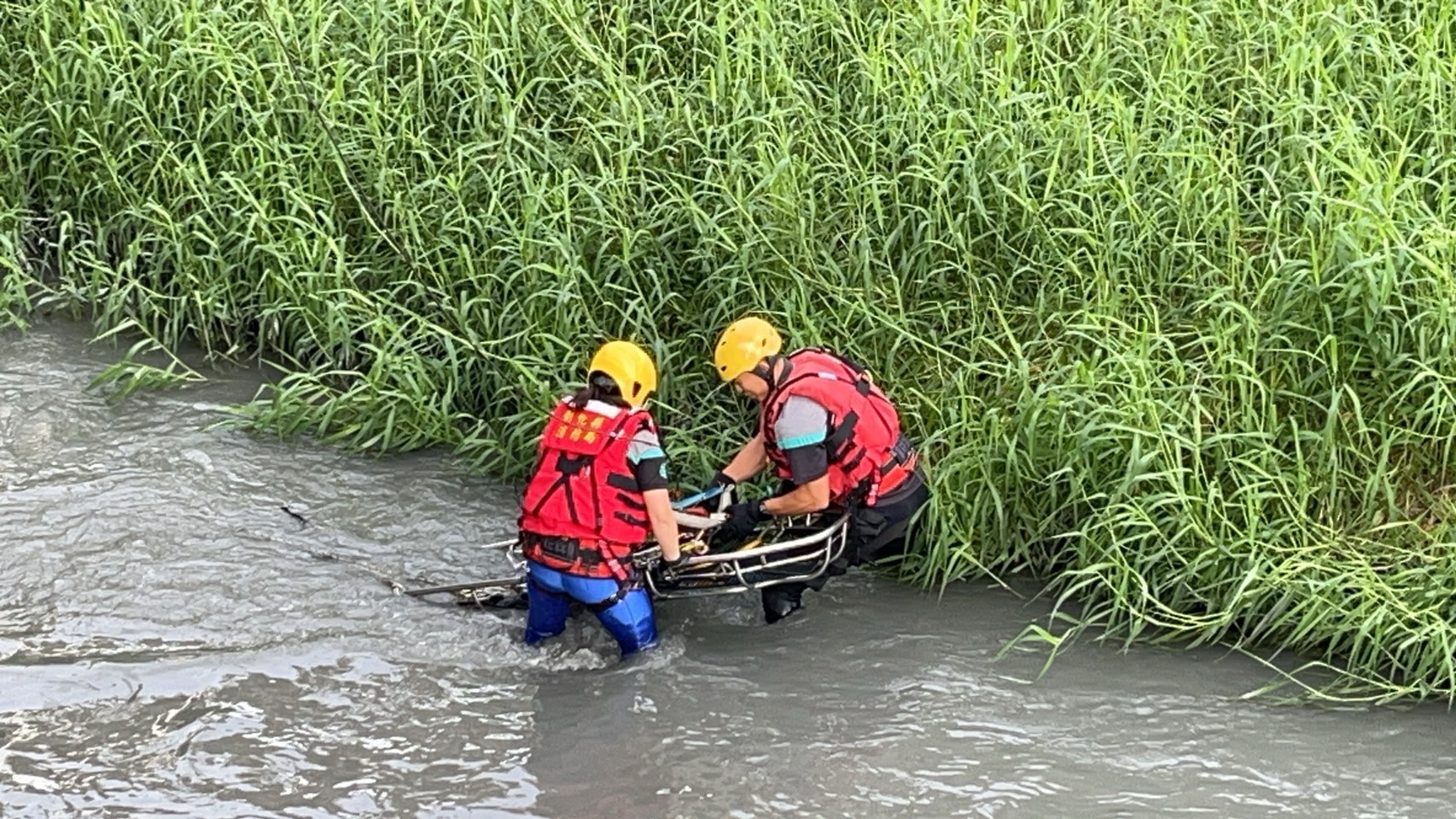 ▲員林市員林大排發生溺水事件，使用器材車將人員吊掛至員大排中進行徒手攔截，再以籃式擔架將溺者吊掛上岸後送醫。（消防局提供）