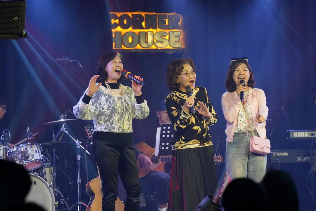 女企業家LUCY獻唱[東方之珠]致敬偶像羅大佑,安可曲邀同在歌唱班的社     區姊妹上台合唱[外婆的澎湖灣],氣氛歡樂。圖左起翠玲(上市公司董     娘)，Lucy，Stela(泰北高中董事長) (喜歡音樂 提供)