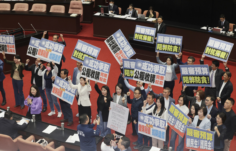明年度總預算案順利付委審查後,國民黨立委舉牌高喊口號宣告爭取成功。中央社
