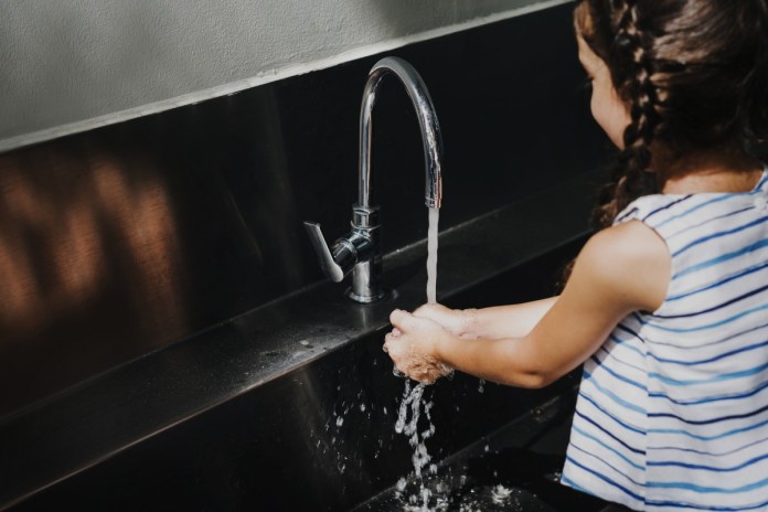little girl washing her hands school