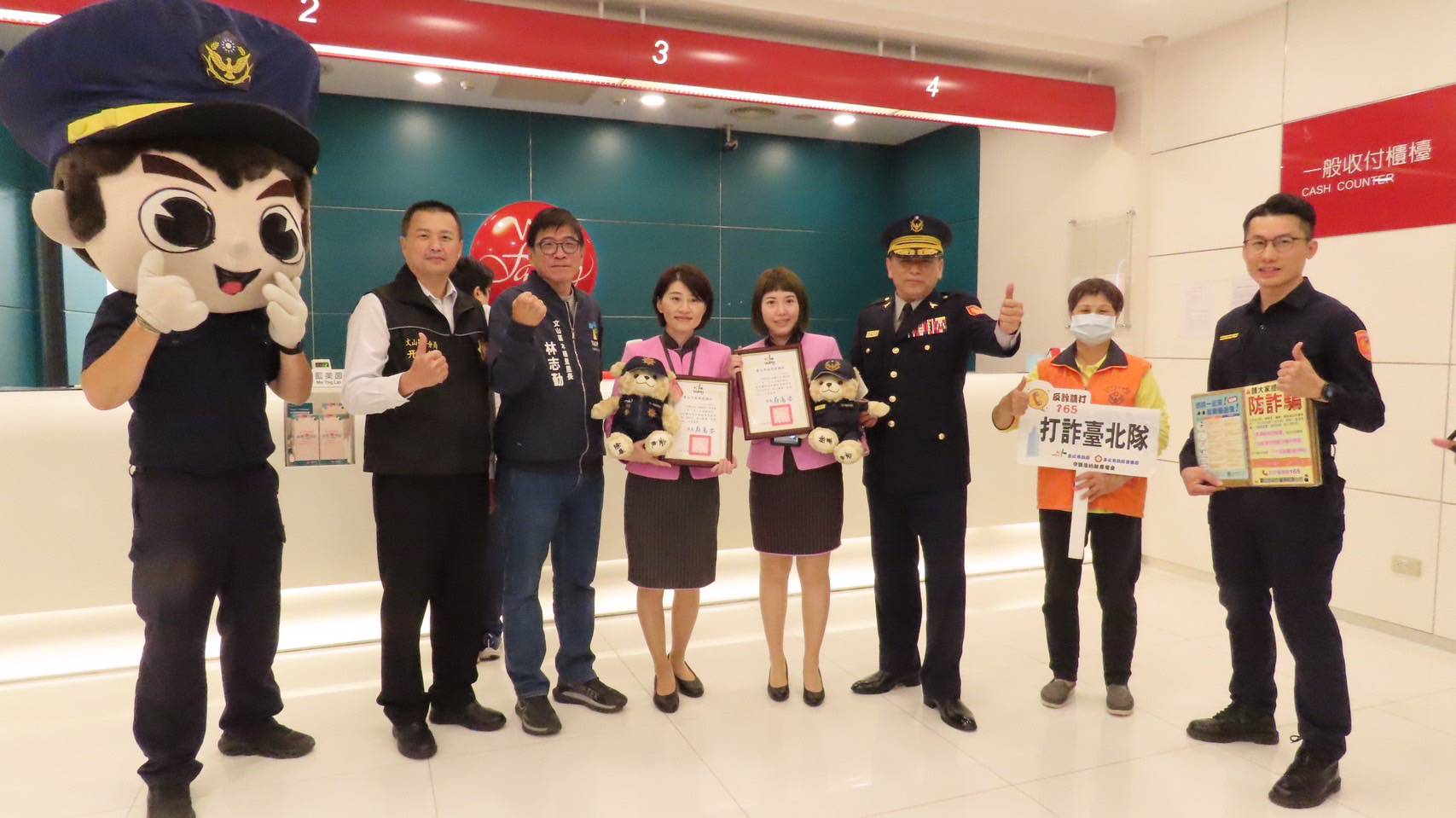 文山第一分局長許城銘親率偵查隊長、派出所所長及象徵反詐守護的「打詐小熊娃娃」至各銀行進行防詐宣導。(記者 黃荷琇翻攝)