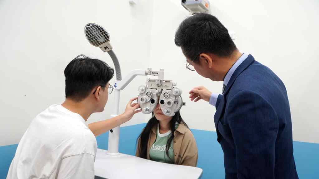 ▲許正格理事長(右)指導大葉大學視光系學生操作儀器。（記者林明佑翻攝）