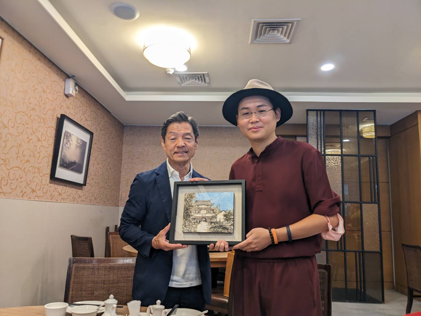 ▲台南年輕畫家邱郁仁贈送畫作給菊池市代表團。（圖／市議員李宗霖服務處提供）