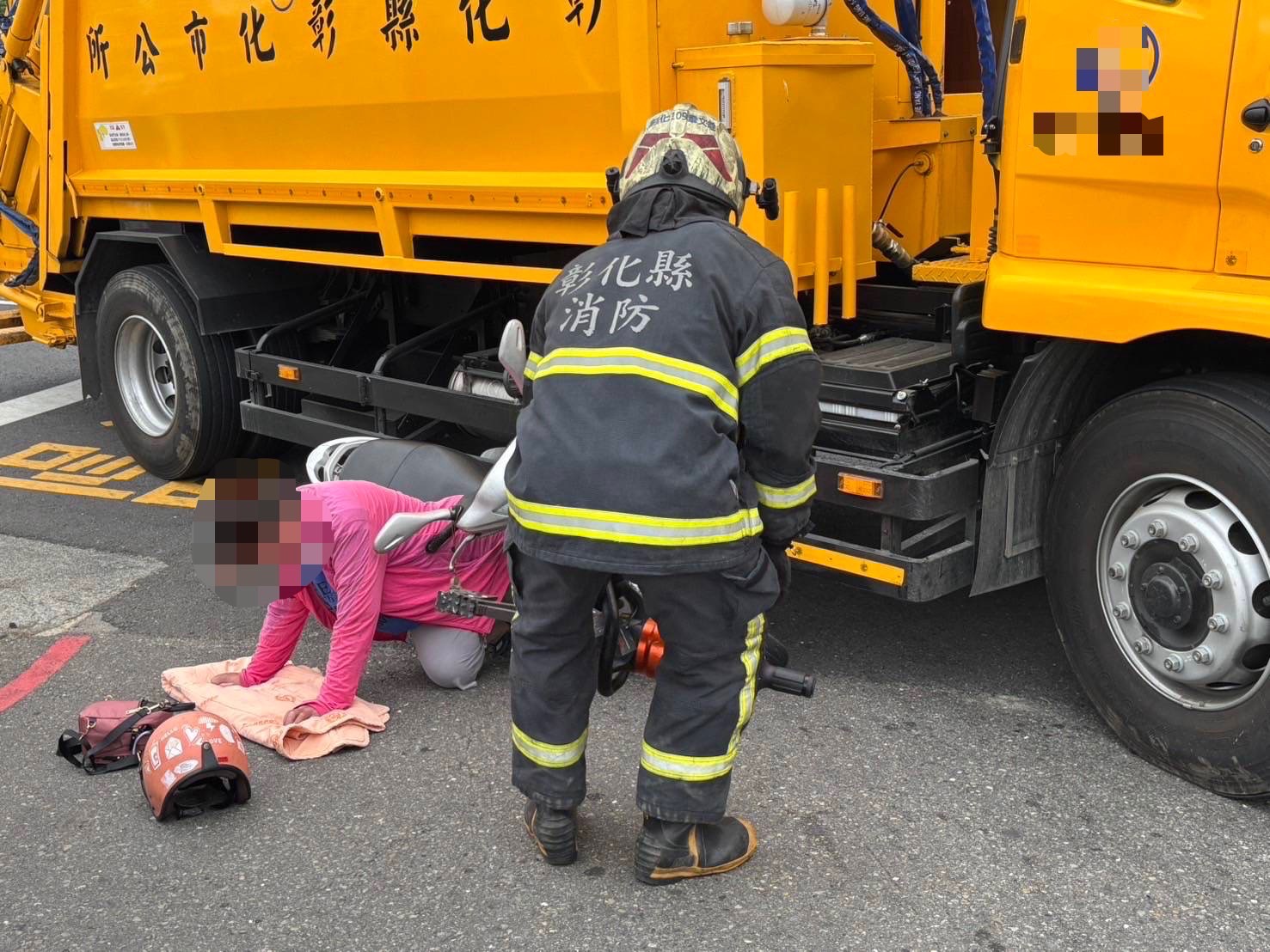 ▲彰化市中華西路與崙美路口發生一起垃圾車與機車擦撞意外，機車騎士摔倒，並被垃圾車夾住左小腿，消防人員用破壞器材搶救。（民眾提供）