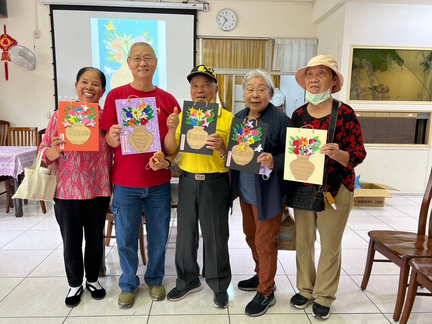 ▲彰化榮家推出「瓶安花開幸福」彩繪剪紙課程，長輩們運用彩色筆為花束著色並剪裁花束。（記者張溎壕攝）