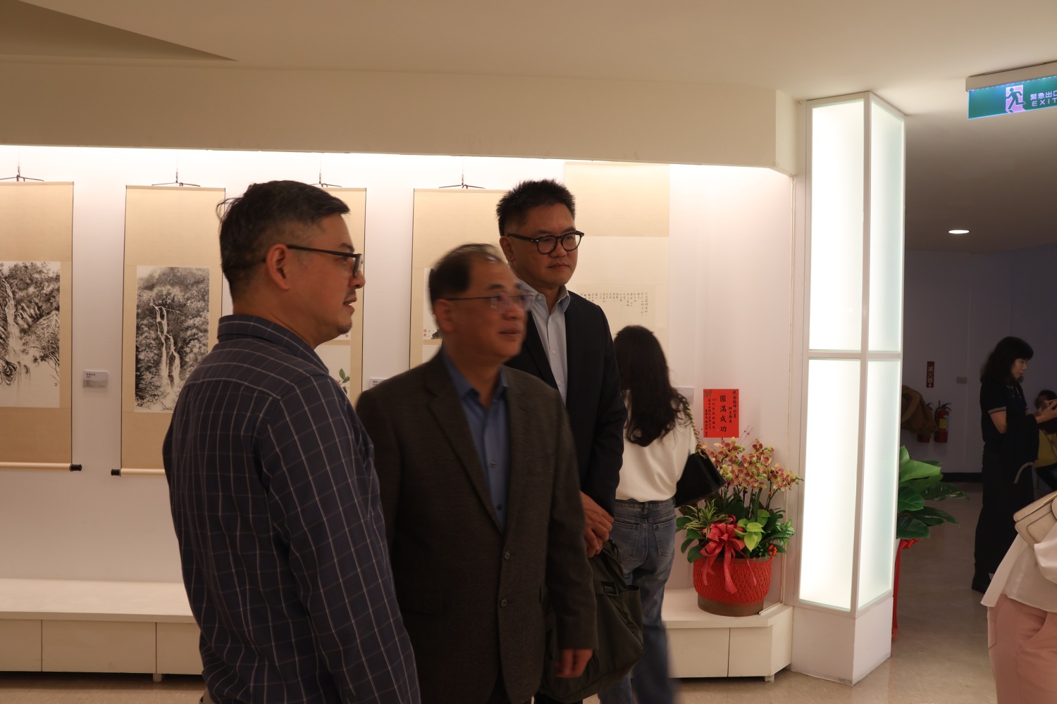 郭振坤(左)向新竹監獄典獄長曾文欽(中)及教化科長劉翰霖(右)介紹畫作。(圖/記者林照東翻攝)