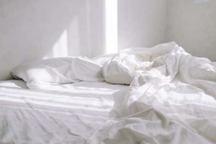 sun falls bed with white sheet bright bedroom