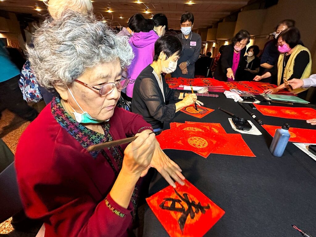 美學書畫班師生現場贈送手寫春聯及年畫。(圖/朝陽科大提供)