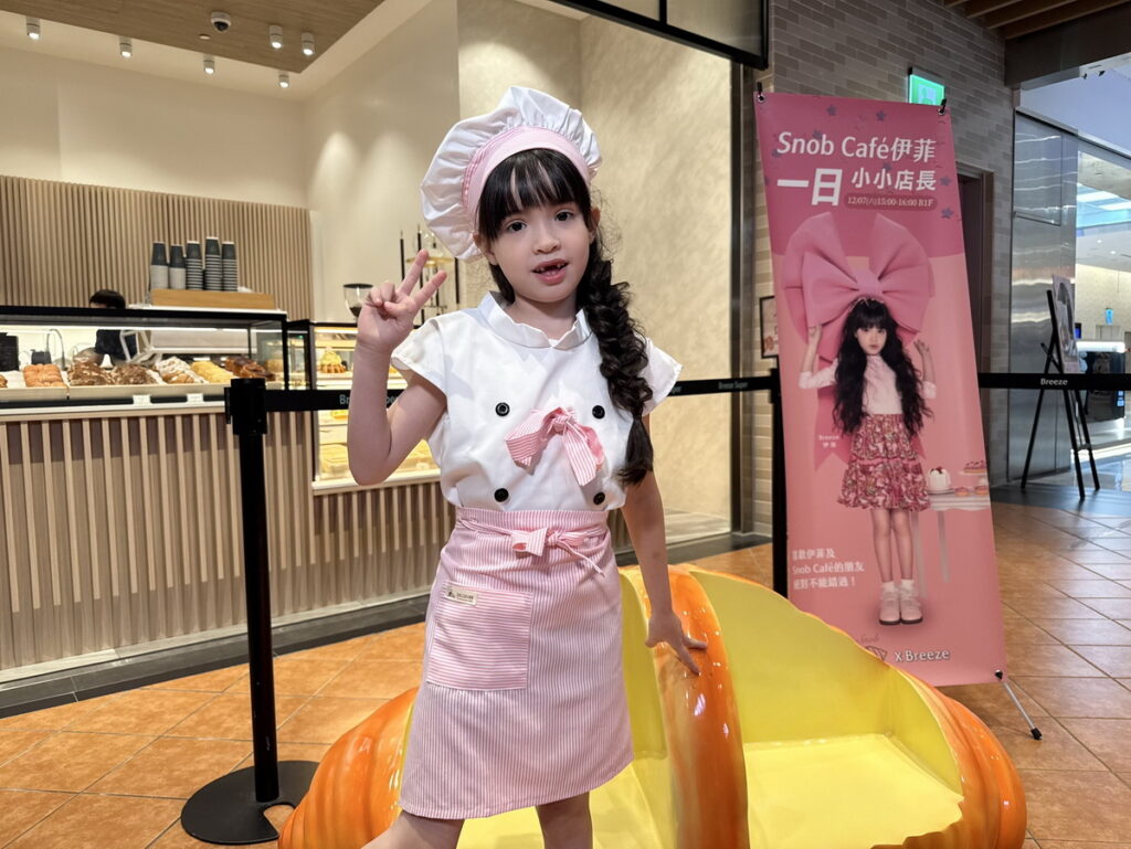 伊菲身穿超萌廚師服與微風南山限定可頌座椅合照