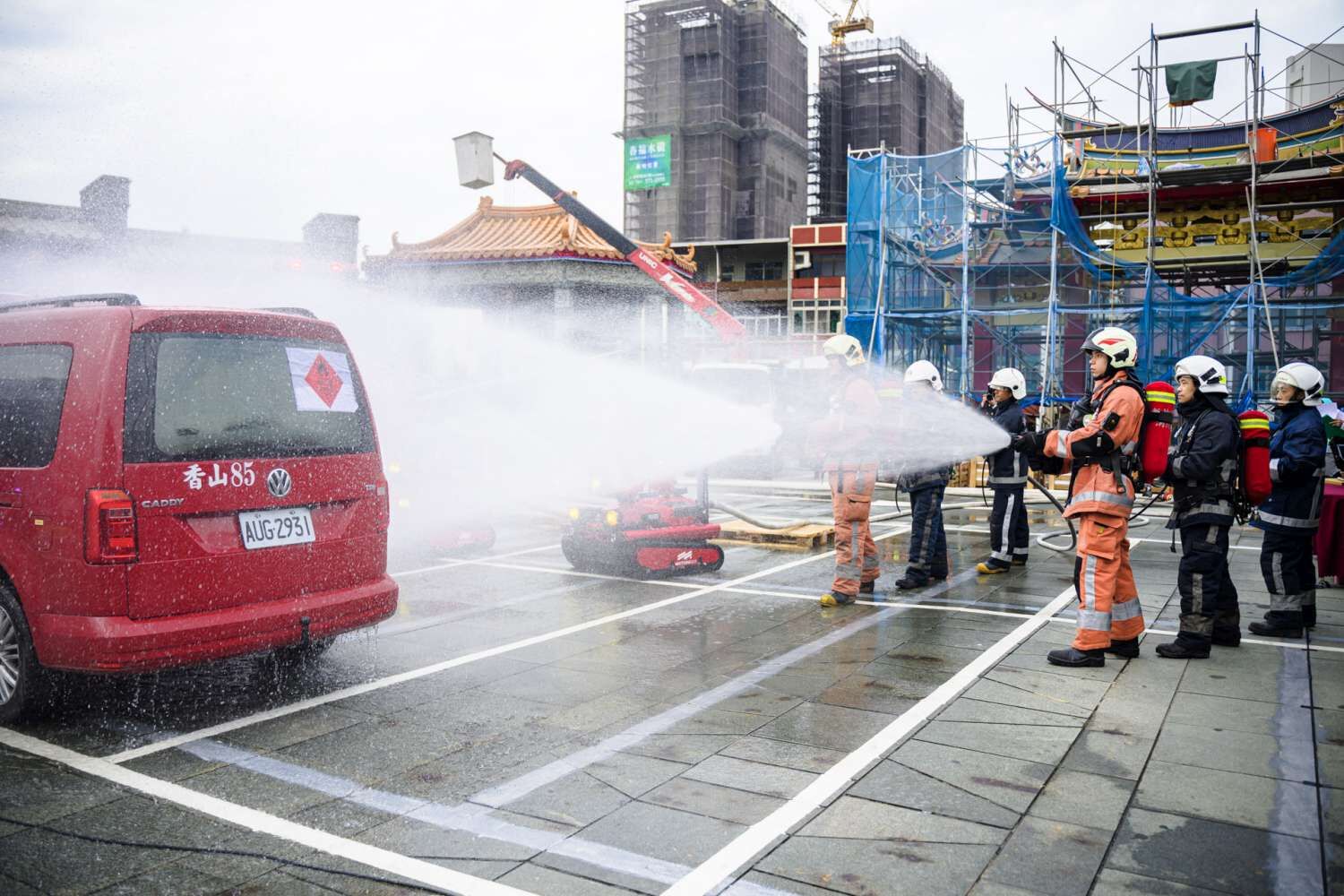 消防局與義消模擬易燃液體車輛火災,結合消防機器人與水線佈署,共同控制火勢,確保救援安全。(圖/記者林照東翻攝)