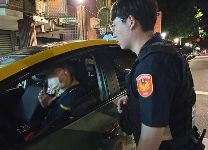 警員李威儀詳細叮囑計程車司機男子的居住地及其酒醉情況,確保男子能平安到家。(記者 黃荷琇翻攝)
