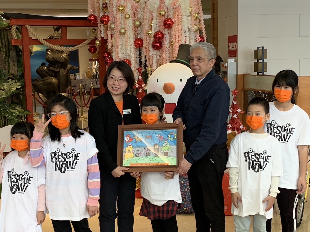 ▲處長將孩子們的畫作贈予耐斯王子飯店鄭百三總經理。（圖/記者陳惲朋攝）