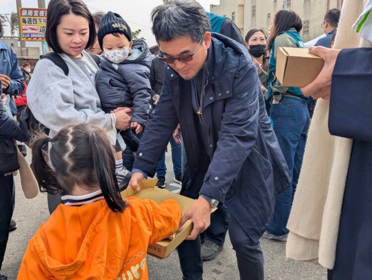 ▲立委劉建國在發表會中發放披薩給學童享用。(記者劉春生攝)
