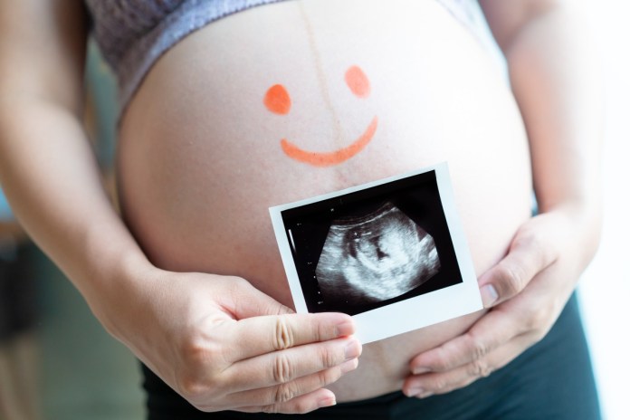 桃園婦幼局明年將放寬生育津貼請領條件 新制規定報你知 72 big belly pregnant woman holding ultrasound film her stomach with drawing kids face