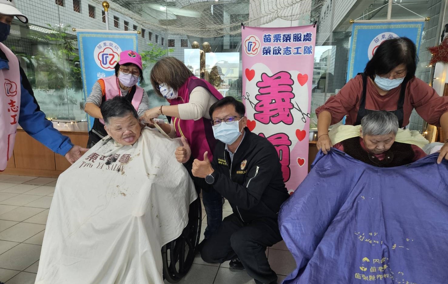 林育文總幹事(中)協助安撫正在理髮的遺眷。(記者 張艷君翻攝)