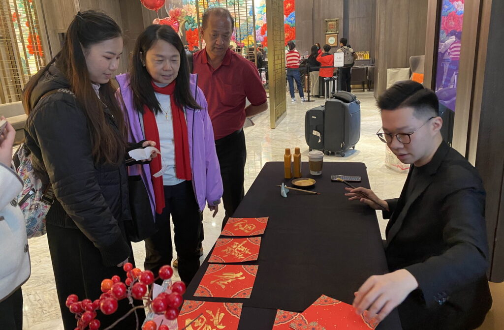 板橋凱撒大飯店於春節期間安排民俗活動,由專業老師揮毫春聯斗方,免費贈送旅客年節小禮作紀念。圖:板橋凱撒大飯店提供