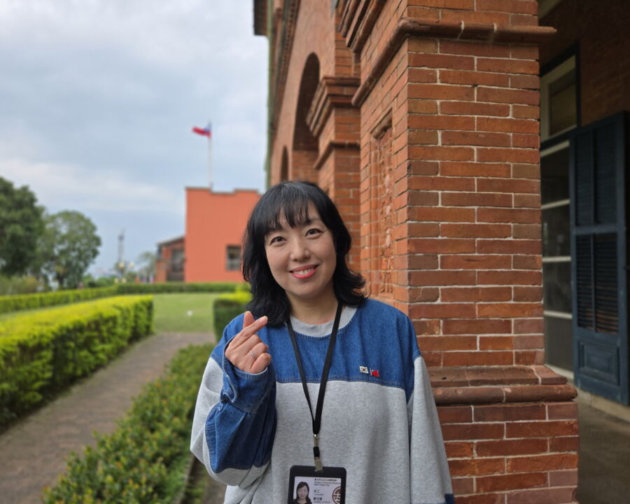 圖/新北市立淡水古蹟博物館首位韓籍志工鄭芝贇,值勤服務時會在胸前掛兩國國旗,方便遊客辨識。(新北市立淡水古蹟博物館提供)