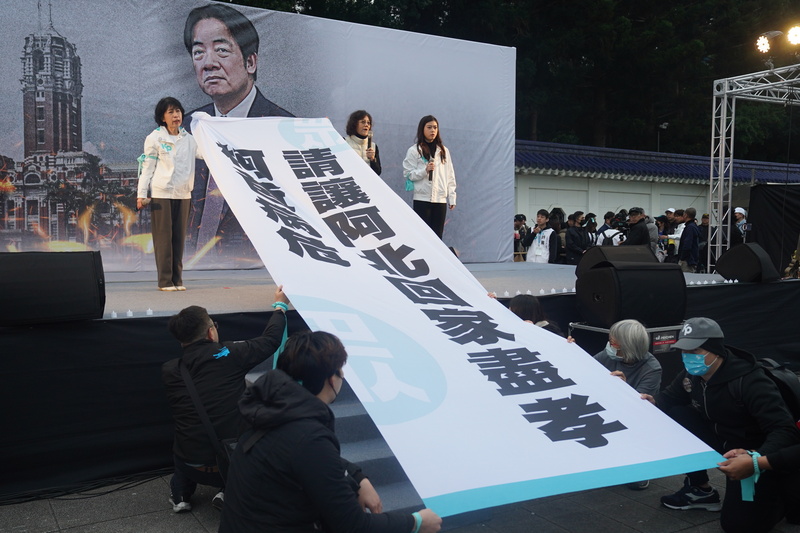 台灣民眾黨11日在自由廣場舉行「111釘孤枝!萬人捍衛司法正義」活動,前黨主席柯文哲的妻子陳佩琪(後左)與妹妹柯美蘭(後左2)上台時拉開巨幅白布條,指「柯爸病危」,盼讓柯文哲能回家盡孝。圖/中央社