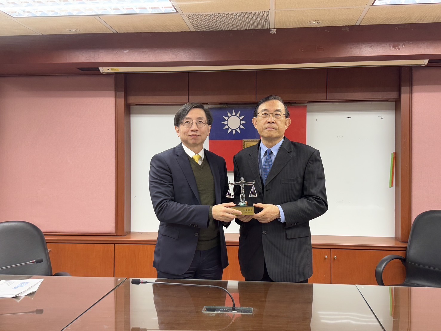 檢察總長邢泰釗(左1)致贈刻有「貢獻殊偉 功垂竹帛」象徵公平正義之天秤造型獎座,感謝檢察長李嘉明(右1)辛勤的領導與貢獻。