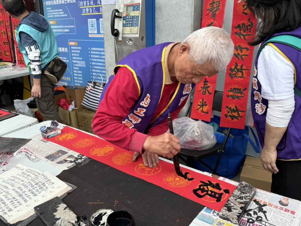 ▲現場民眾大排長龍等候求字，彰化市民們熱情十足，等待領取書法名家的春聯。（記者林明佑攝）