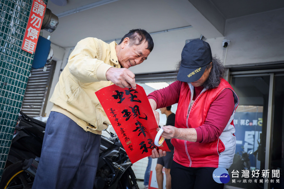 民眾拿到春聯難掩興奮，馬上張貼全新春聯