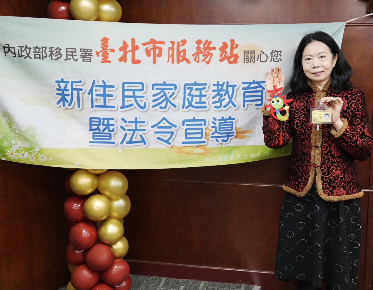 新住民沈曉迪拿著臺大醫院工作證,與現場新住民分享從事長照心路歷程,並以在臺大醫院服務為榮。(記者 黃荷琇翻攝)