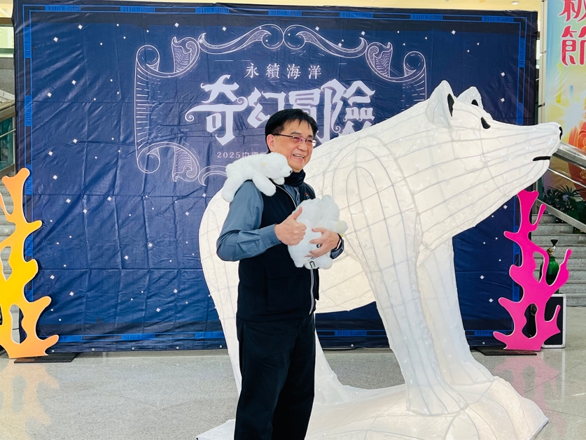 臺中市政府農業局局長張敬昌和燈組「冰晶守護者-親子北極熊」合影,北極熊燈組總高八公尺,凸顯極地融冰議題。圖/臺中市政府農業局