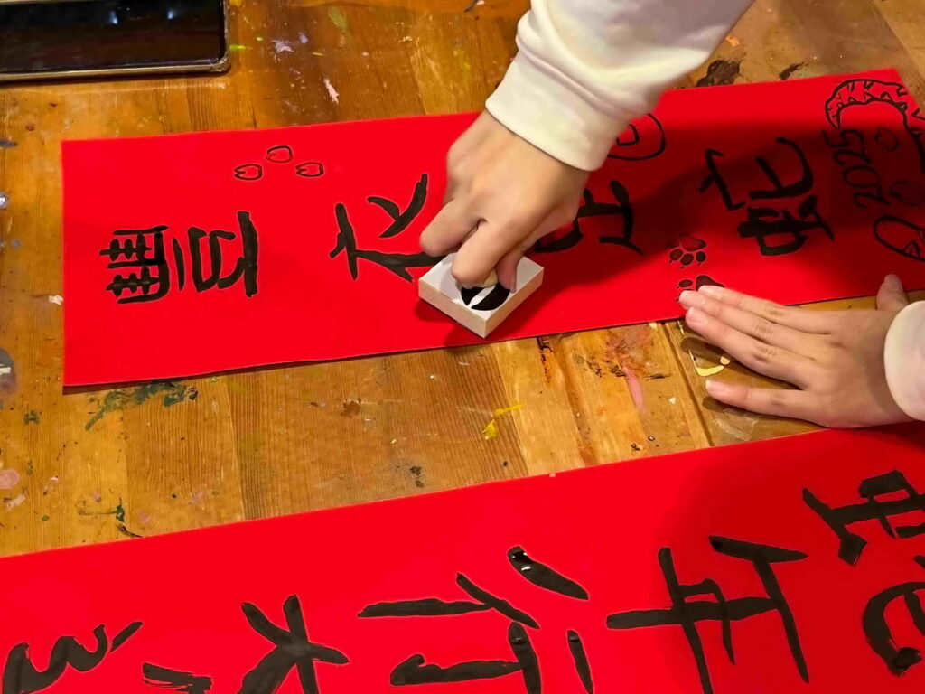慶新年親子體驗動物腳丫拓印春聯,動手DIY玩創意。