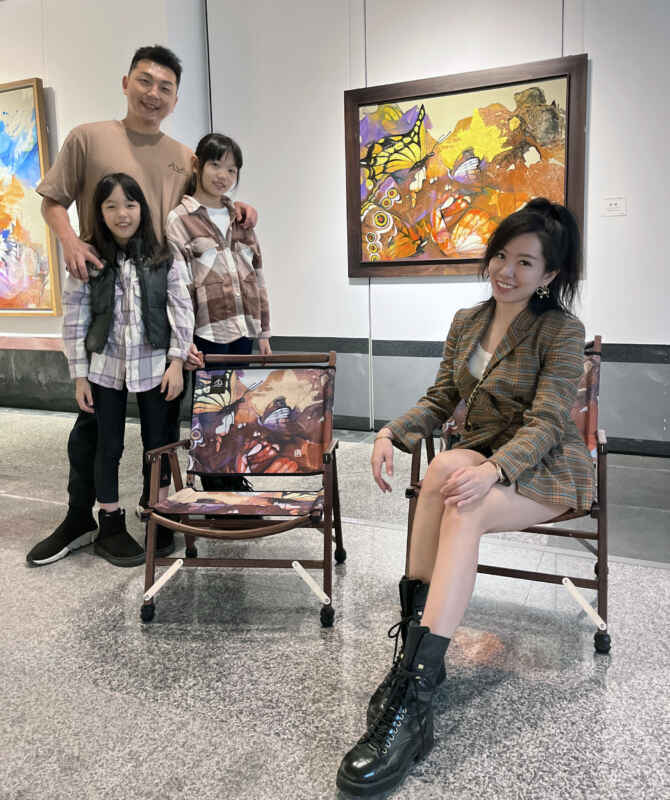 莊明中的作品被開發文創商品椅子，王先生一家特地將椅子拿來展場與原作《蝶舞》合影。