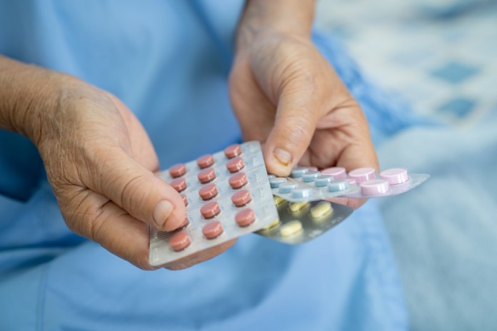 過年小酌「藥」注意 這些人應避免飲酒 55 asian senior elderly old lady woman patient holding antibiotics capsule pills