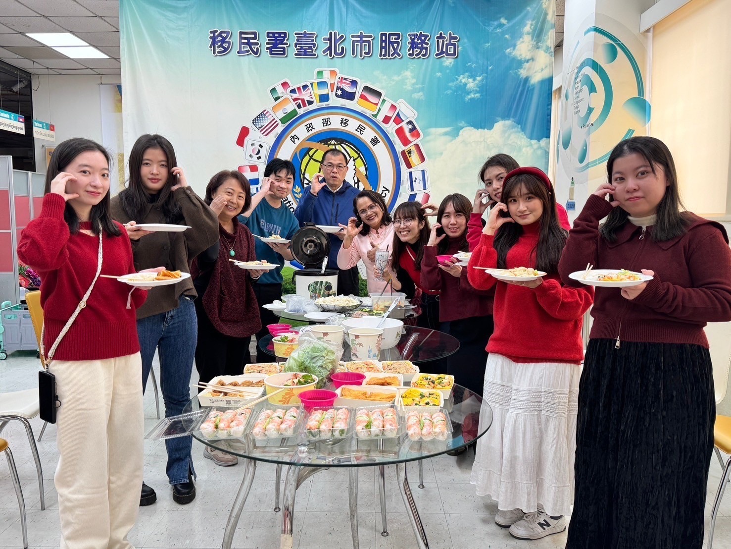 移民署臺北市服務站主任蘇慧雯(左3)與新住民二代親善大使團體驗異國年味的圍爐,享用越南過年必吃年菜「春捲」,DIY泰式米線和摩摩喳喳。(記者 黃荷琇翻攝)