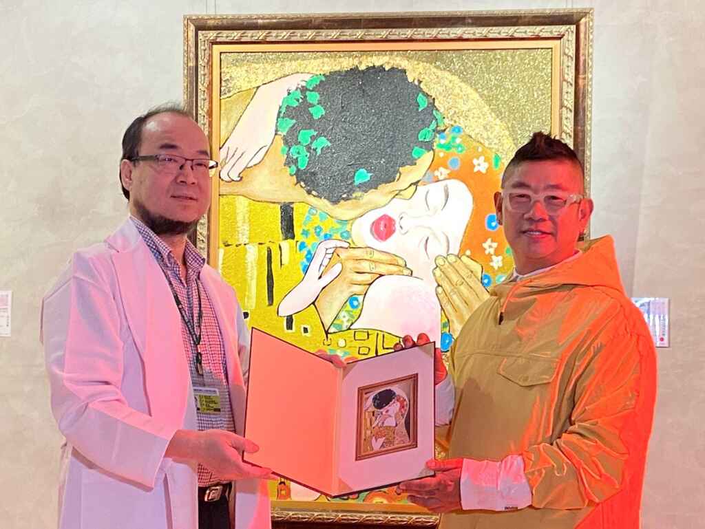 ▲藝術家簡明正（右）捐贈畫作 「吻。克林姆」 ，由彰濱秀傳醫院副院長徐永南（左）代表接受。（秀傳醫院提供）
