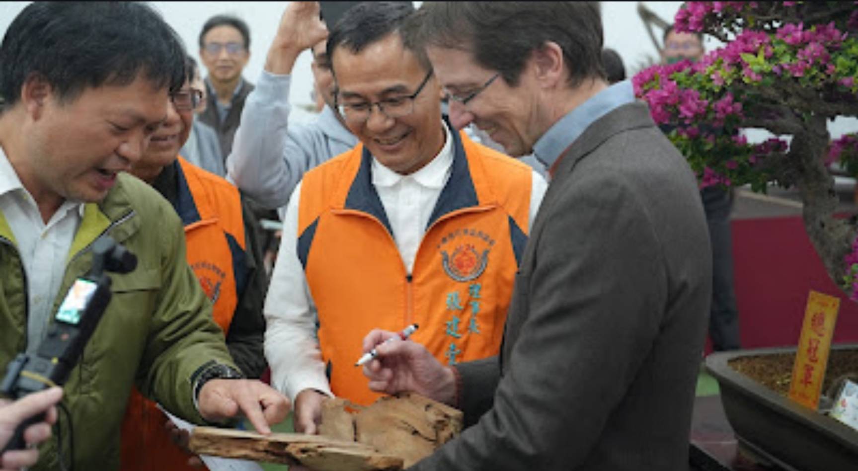 理事長張建壹(中)特別準備台灣非常珍貴的檜木,並製成有刻上安德烈先生名字的稀有雕刻,且邀請他簽名留念,為此次的國際交流活動劃下了完美的句點。(記者 趙靜姸翻攝)