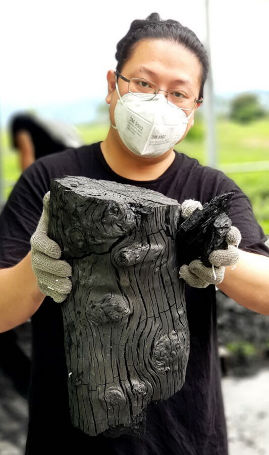 圖/手工龍眼木炭與阿賢。(呂明賢提供)