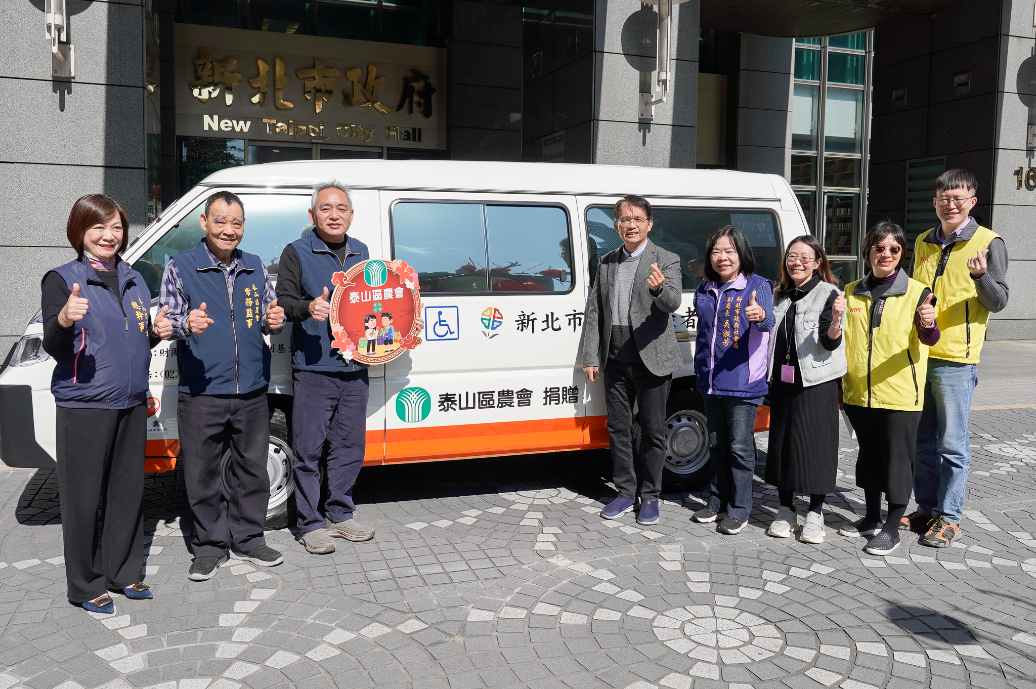 《圖說》新北市泰山區農會將盈餘回饋在地,今日由農會理事長謝文雄(左3)帶領常務監事陳和明(左2)及總幹事李愛娟(左1),捐贈新北市復康巴士,嘉惠在地市民。〈社會局提供〉